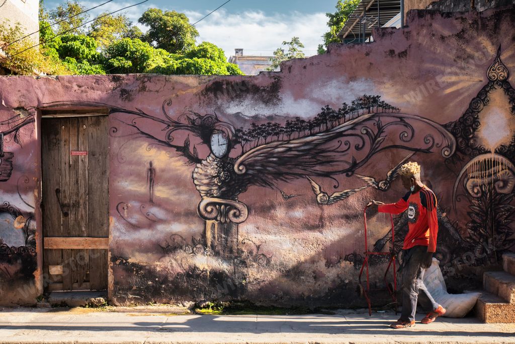 An African-American boy painting graffiti on the wall