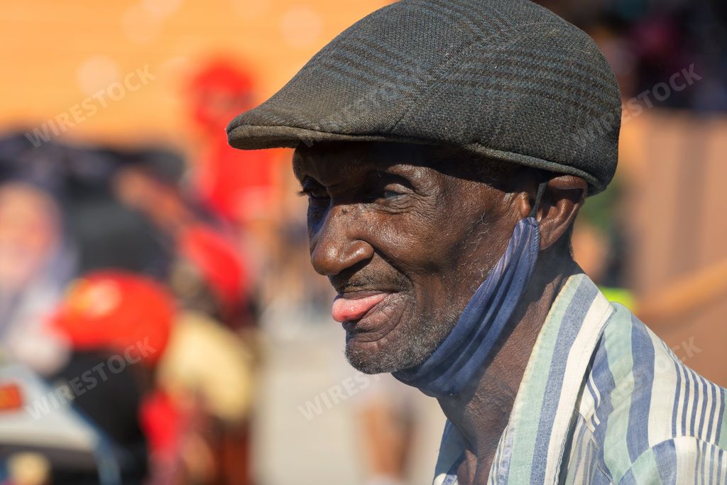A selective focus shot of an old Cuban male licking his lips