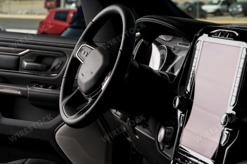 A closeup shot of a steering wheel and modern-designed interior setup inside a car