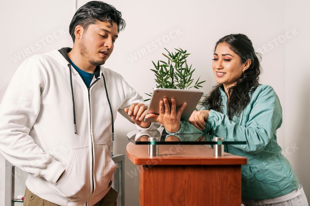 A young latina receptionist talking to a man in a dental clinic