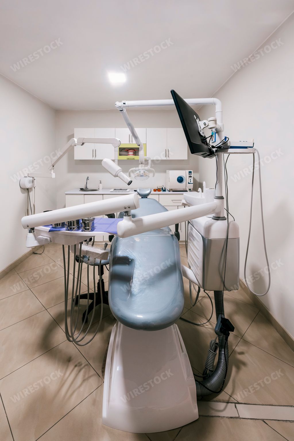 A vertical shot of a stretcher in an empty dental clinic room ready for use