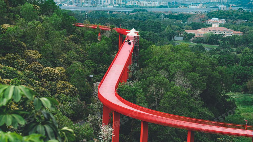 A vibrant red sky trestle bridge stands out in the background of Hongqiao Park in Guangming District, Shenzhen