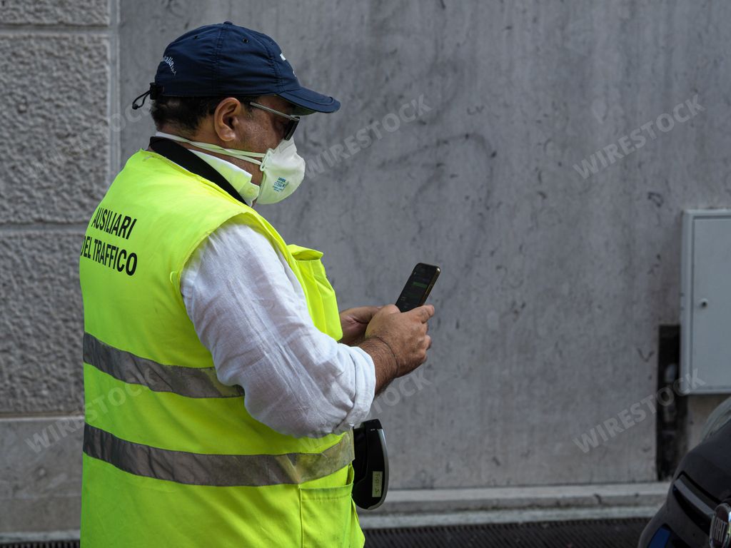 Parking attendant verifying online and issuing printing parking fine in the str