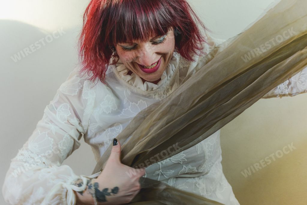 A playful caucasian young adult redhead woman having fun in a room
