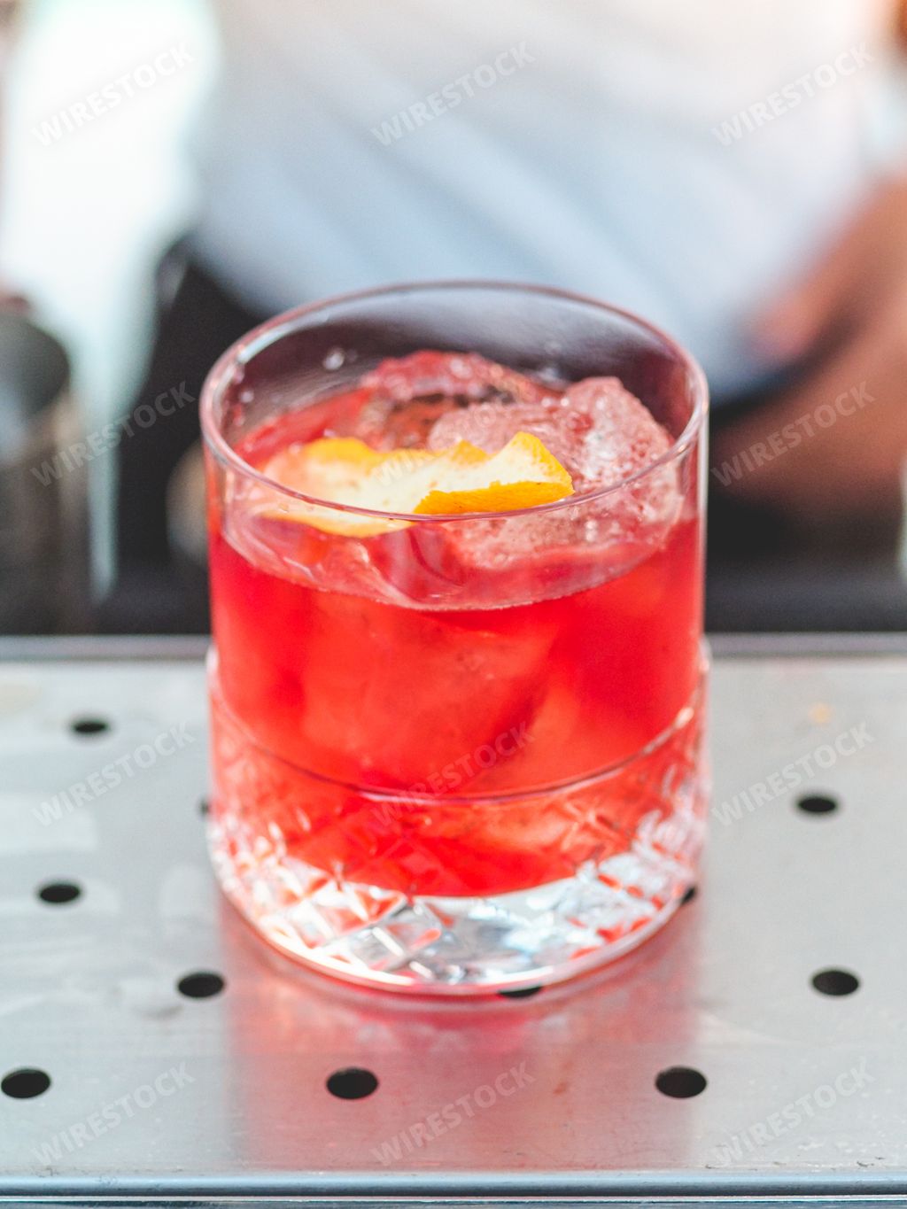 A vertical shot of a negroni campari aperol cranberry cocktail