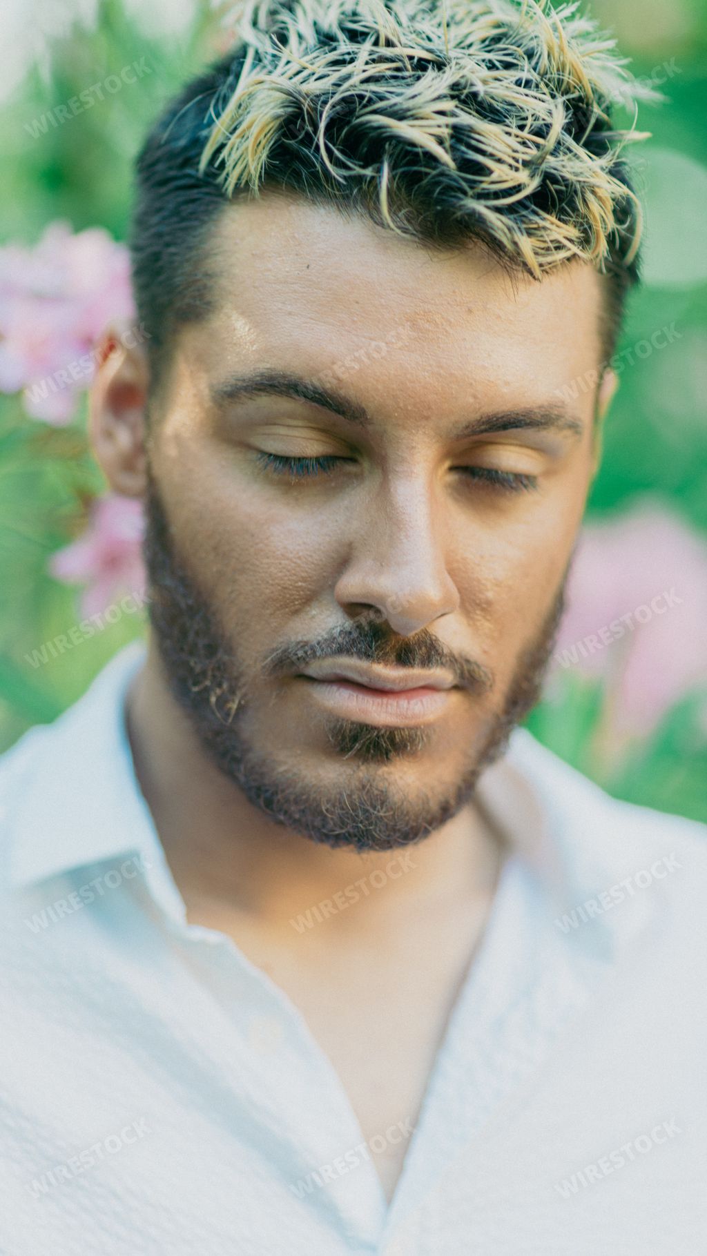 A vertical shot of a young attractive Caucasian guy from Italy with his eyes closed