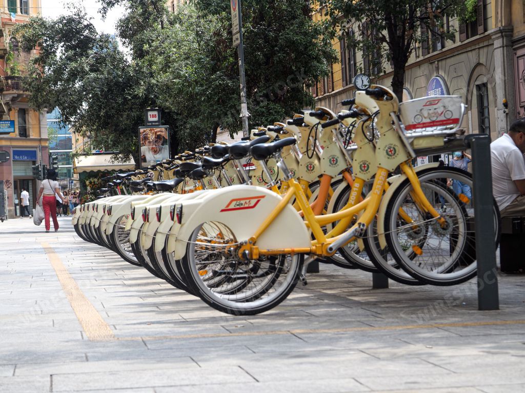A row of electric and traditional city bikes for a rental by an app in Milan, Italy