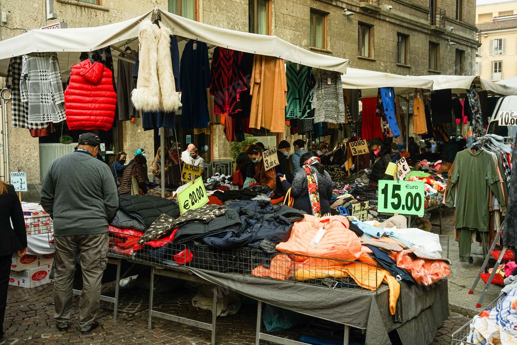 Local people shopping at a cheap street clothing market in Cremona, Italy