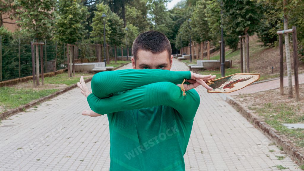 An Italian boy with a turquoise sweater covering his face with arms