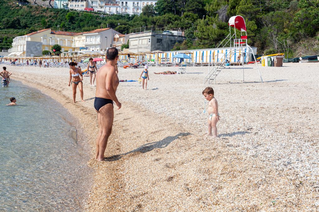Italian local tourist, enjoys not so crowded beach in summertime following distancing rules at the adriatic sea