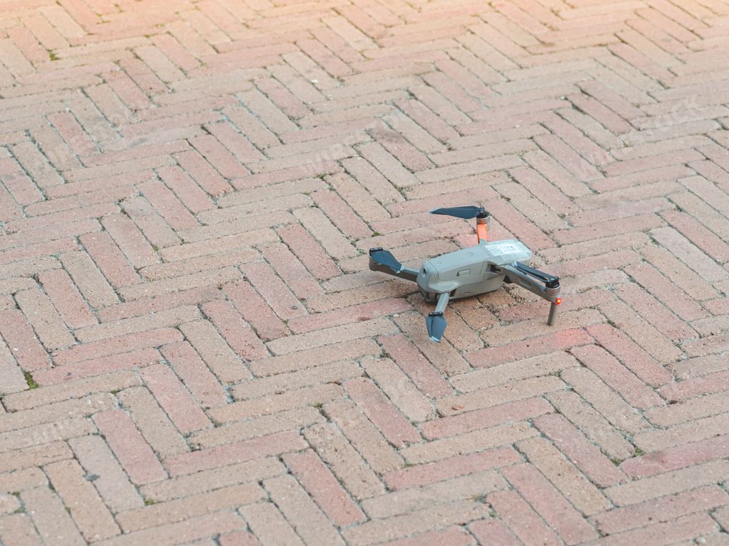 A drone with a cobblestone road in the background