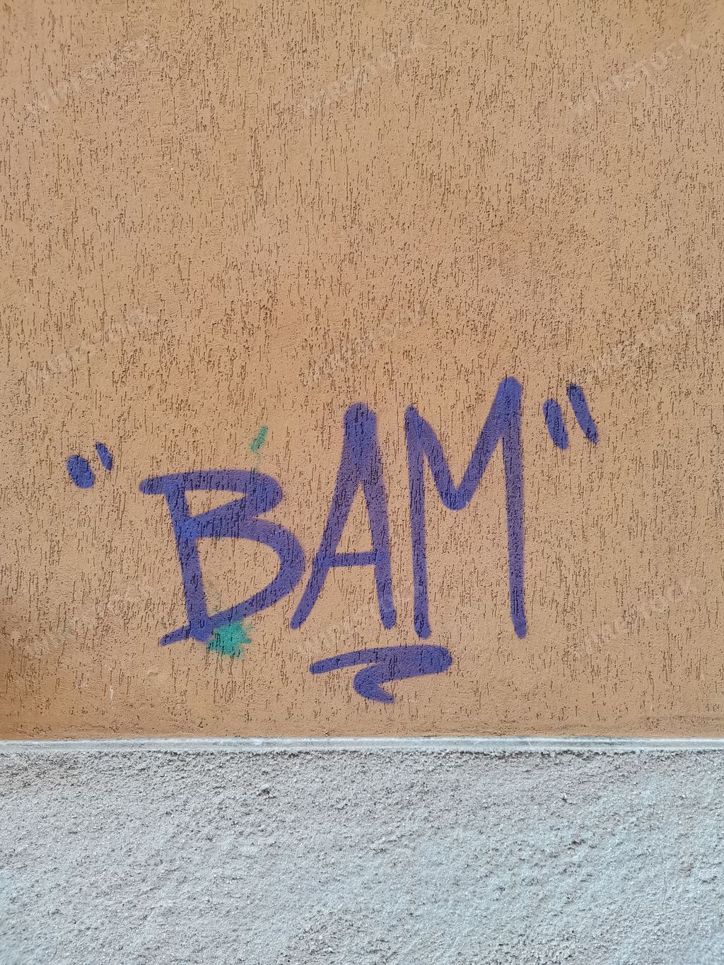 Bam written text graffiti on a brown wall