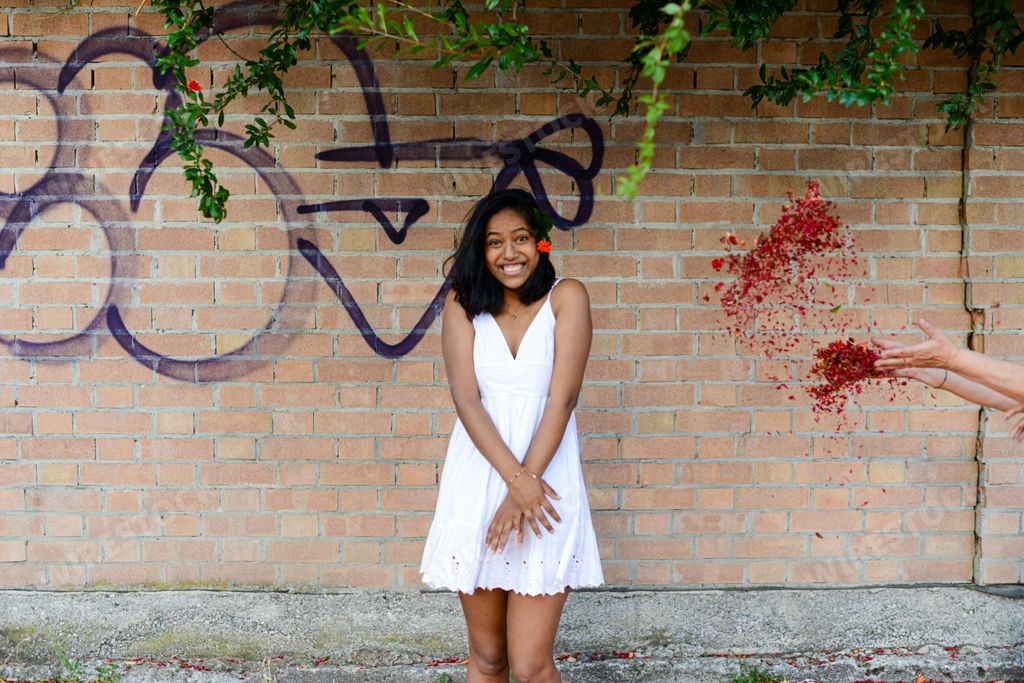 An East Asian female in an urban environment in front of a graffiti wall