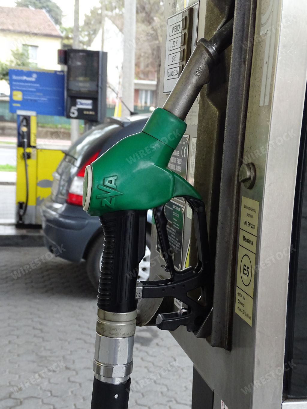 A vertical photo of a green pump at the fuel station