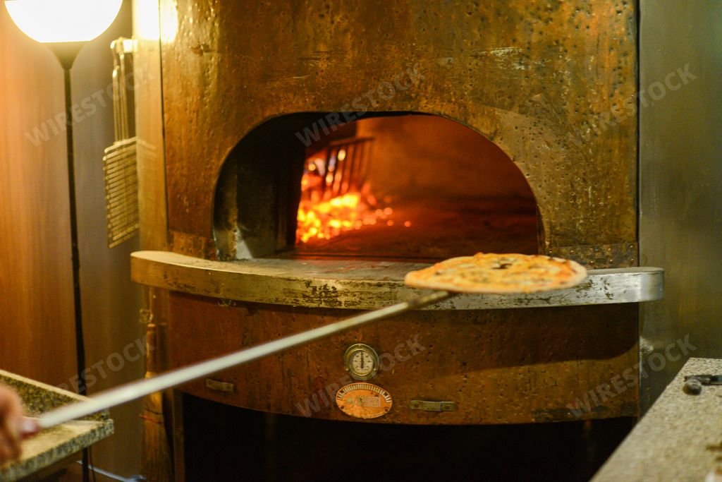 A closeup shot of pizzas inside a traditional copper oven fueled by wood in Mignano, Italy