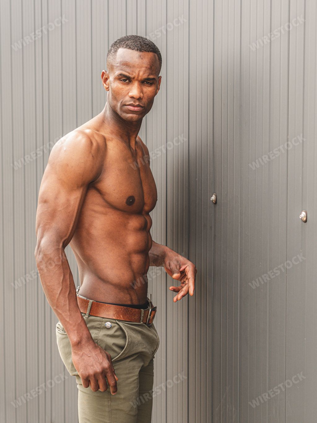A shirtless African man demonstrating his torso with perfect abs