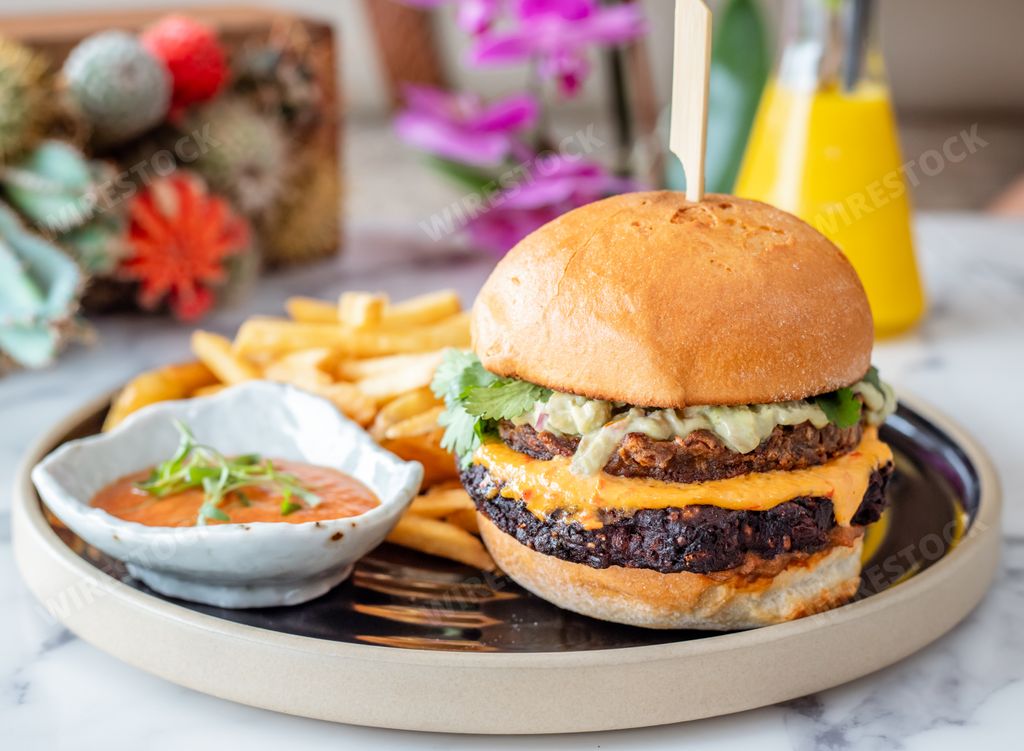 A closeup shot of beef burger accompanied with fries and ketchup