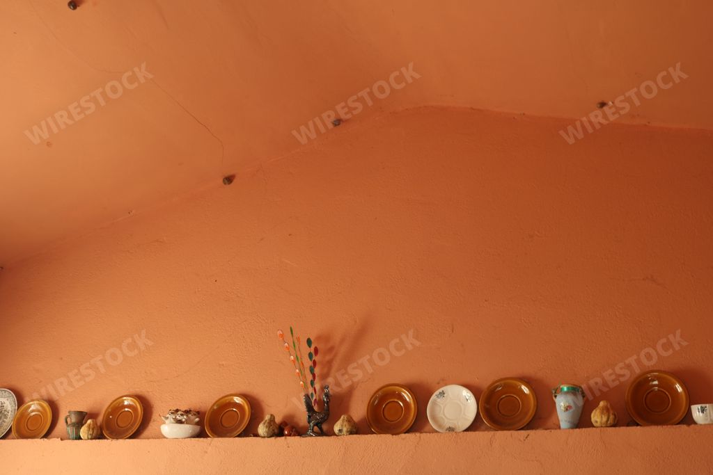 A lot of different ancient plates and decorations on a shelf