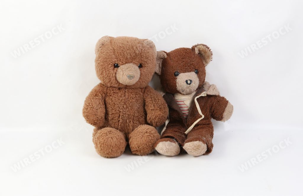 Two old brown damaged teddy bears isolated on a white background