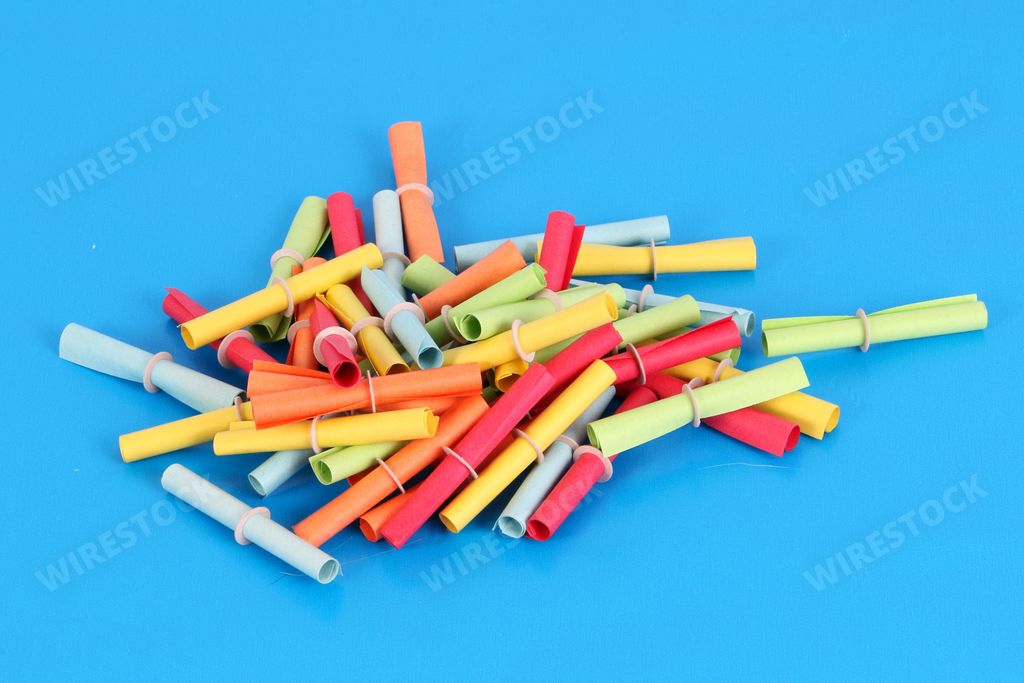 A closeup of a heap of colorful tombola tickets on a blue background