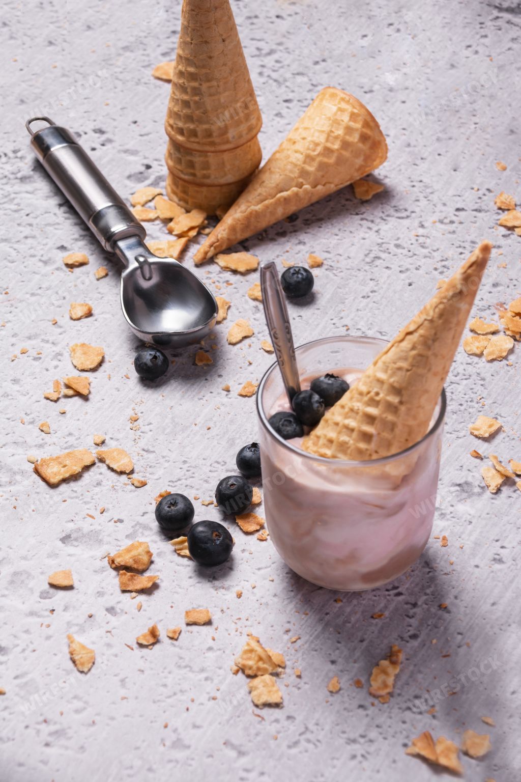 A waffle cone in a glass of mixed chocolate and fruit ice cream