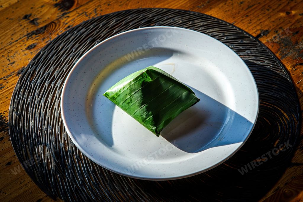 Sunrise nasi lemak wrapped in a banana leaf Nasi lemak is a Malay cuisine dish consisting of fragrant rice cooked in coconut milk and pandan leaf