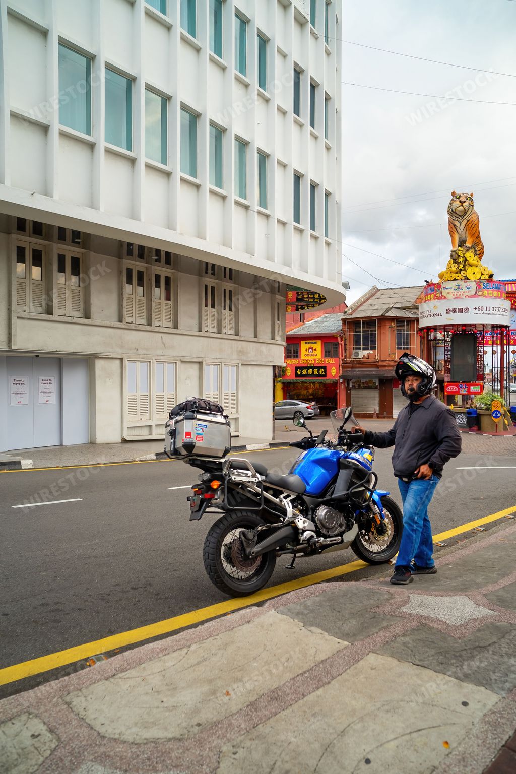 Melaka, Malaysia - Aug 25, 2022 Super Tenere S10 motorcycle with the rider stopping at the Jonker walk street in Malacca.