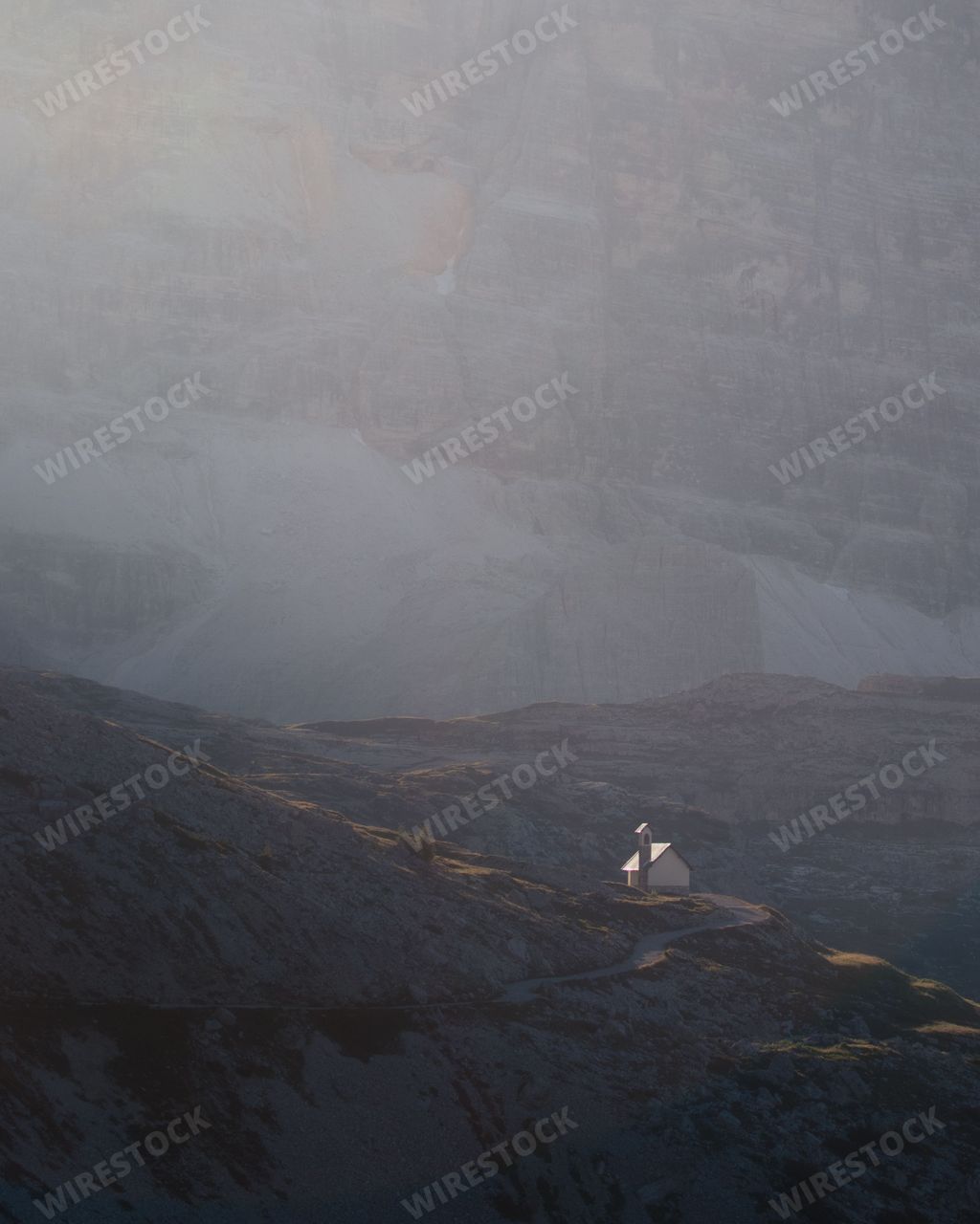 A vertical shot of a lonely house on the top of the hill