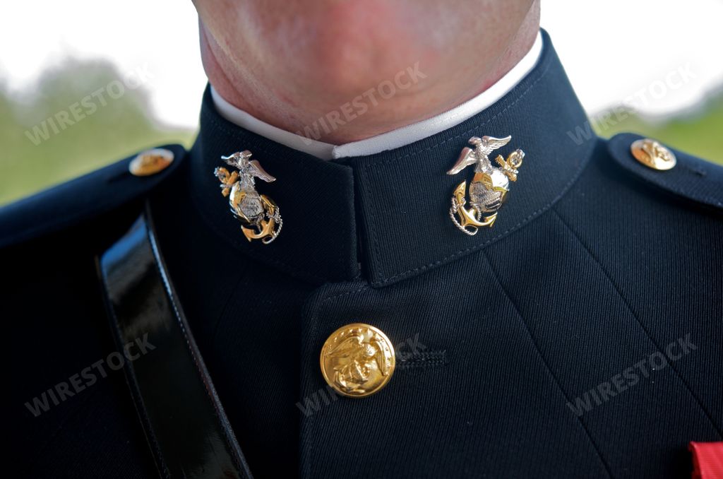 A closeup of a groom's marine corps uniform symbols dressed on his wedding day