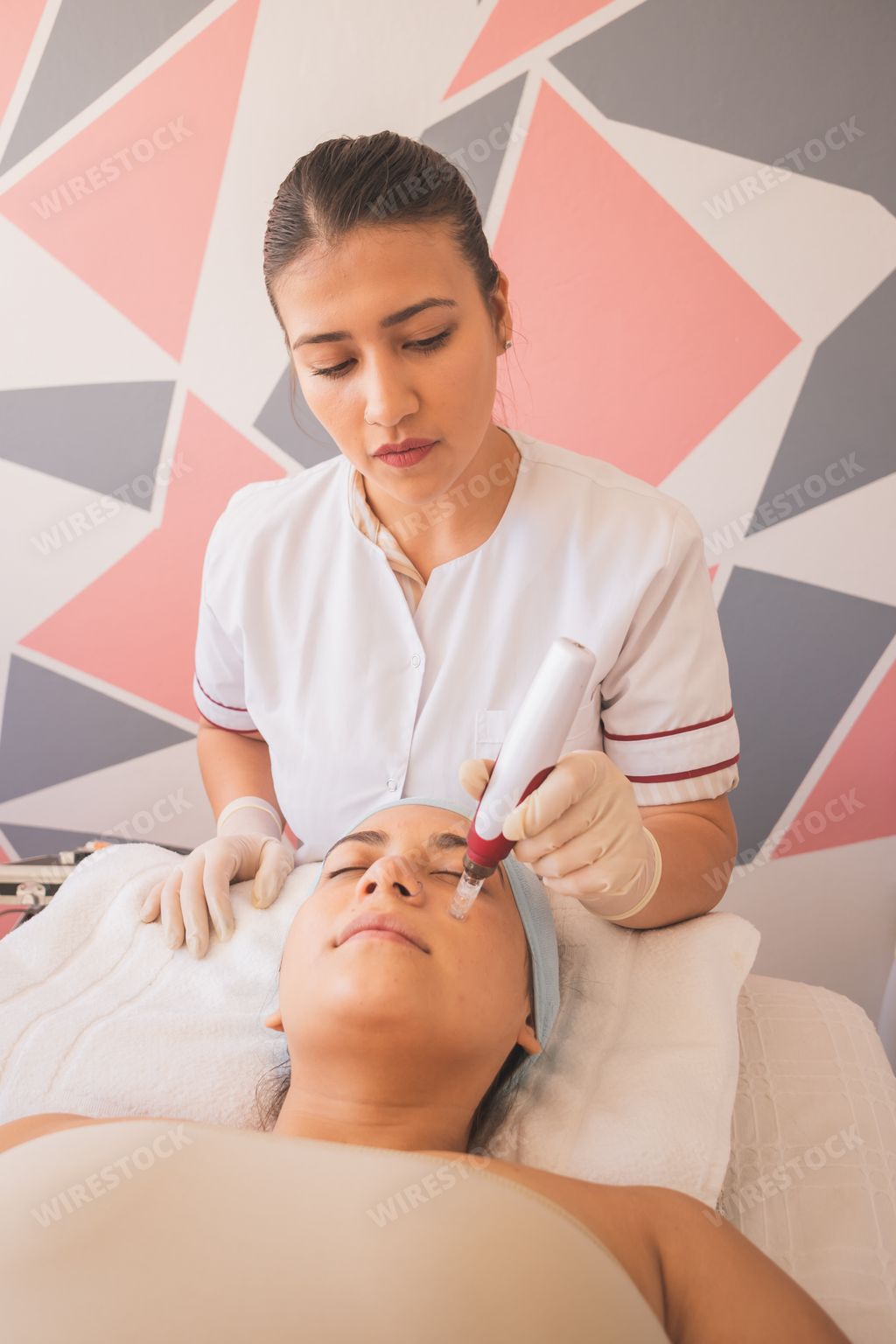 A vertical shot of a young Hispanic female getting a facial at a spa