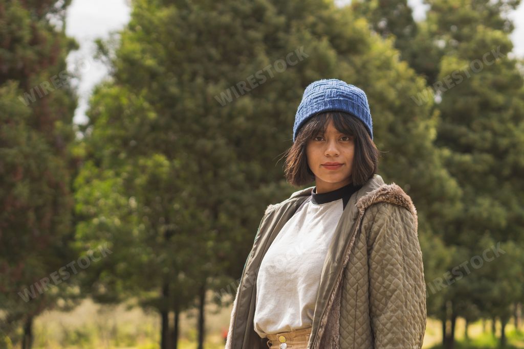 A young Hispanic woman walking through nature, enjoying the scenery
