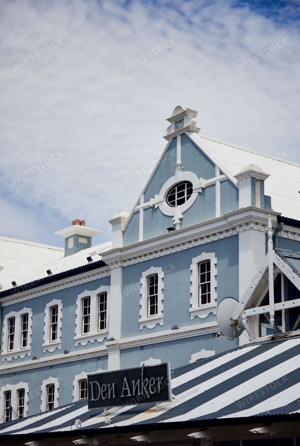 Vertical view of the historic building Der Anker on embankment in Cape Town, South Africa under blue cloudy sky