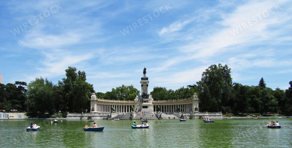 A scenic view of Retiro Park with boats floating on the tranquil lake. Madrid, Spain.