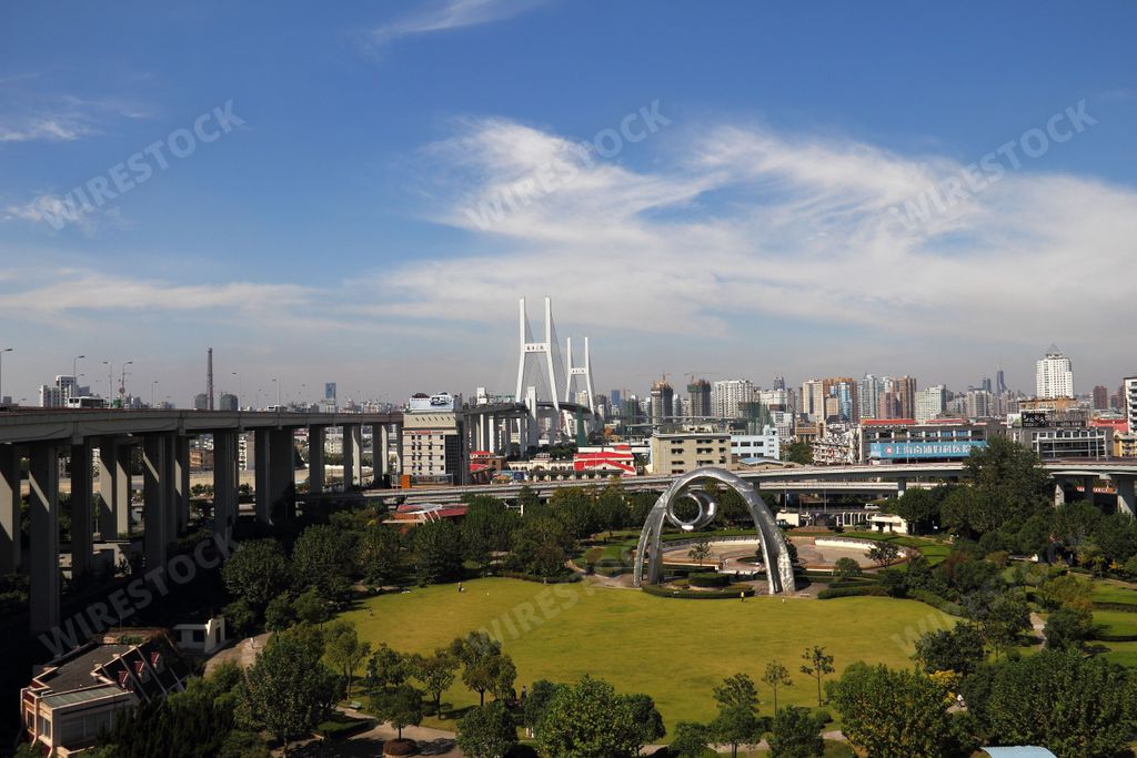 An aerial view of a bustling urban skyline in Shanghai, China, featuring a mix of modern and traditional high-rise buildings