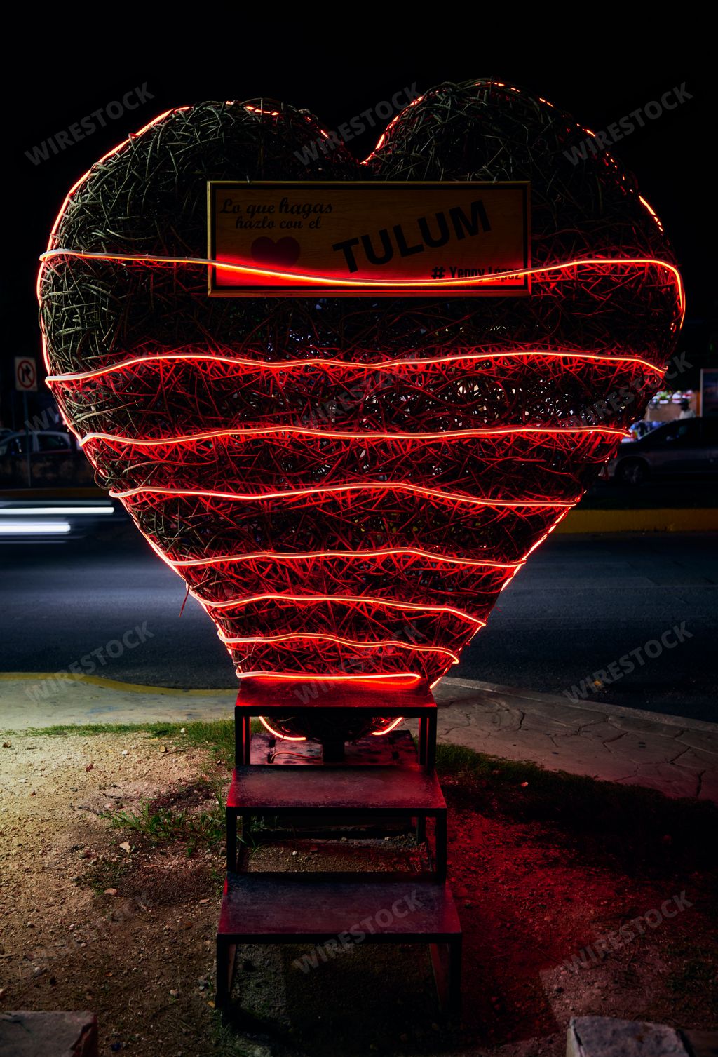 A vertical shot of a wicker heart wrapped in red LED light as landmark in Tulum, Quintana Roo, Mexico