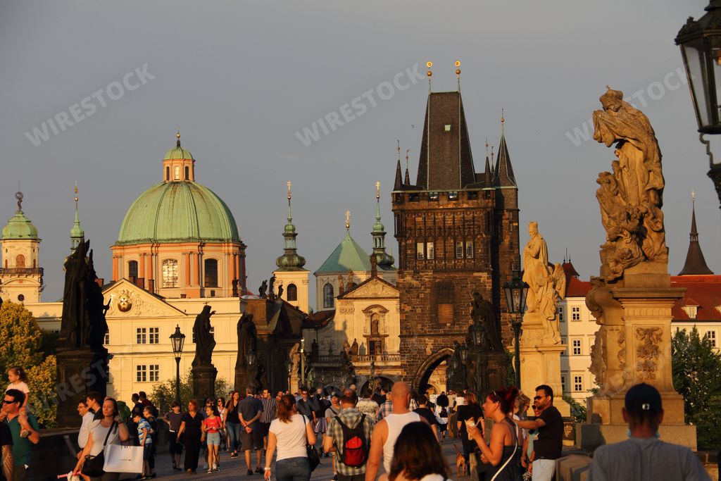 The crowded Charles bridge in Prague at sunset