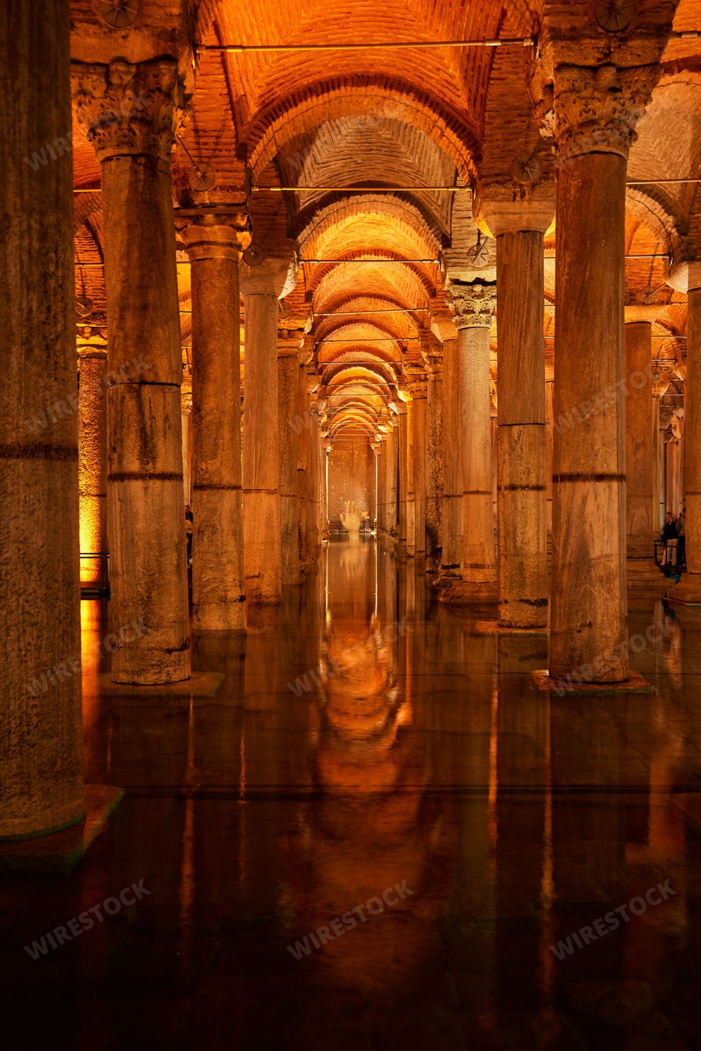 A view of a cisterne in Istanbul featuring an underground passageway with a stone floor and arched ceiling