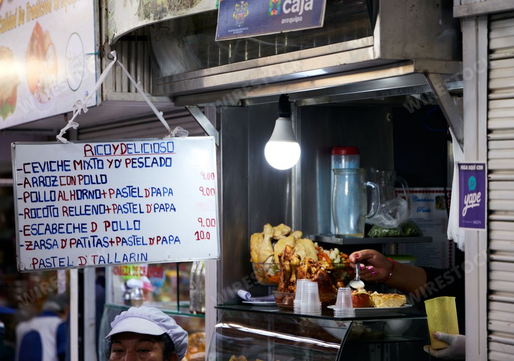 A banner with the price list ad Mercado San Camilo food market in Arequipa, Peru