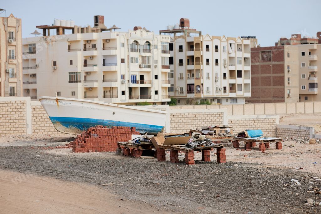 A boat docked by a construction site on the beach
