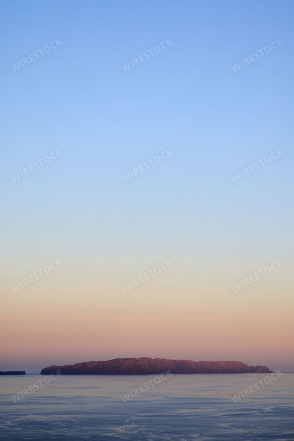 A scenic view of Madeira Island coastline at sunset with mountains in the background