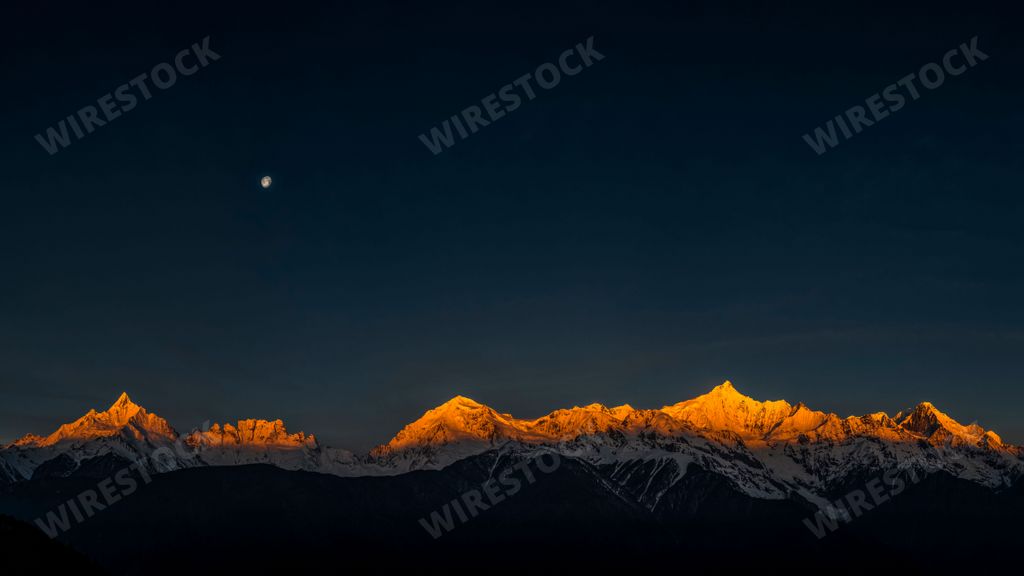 A beautiful landscape of mountains covered in snow on the sunrise