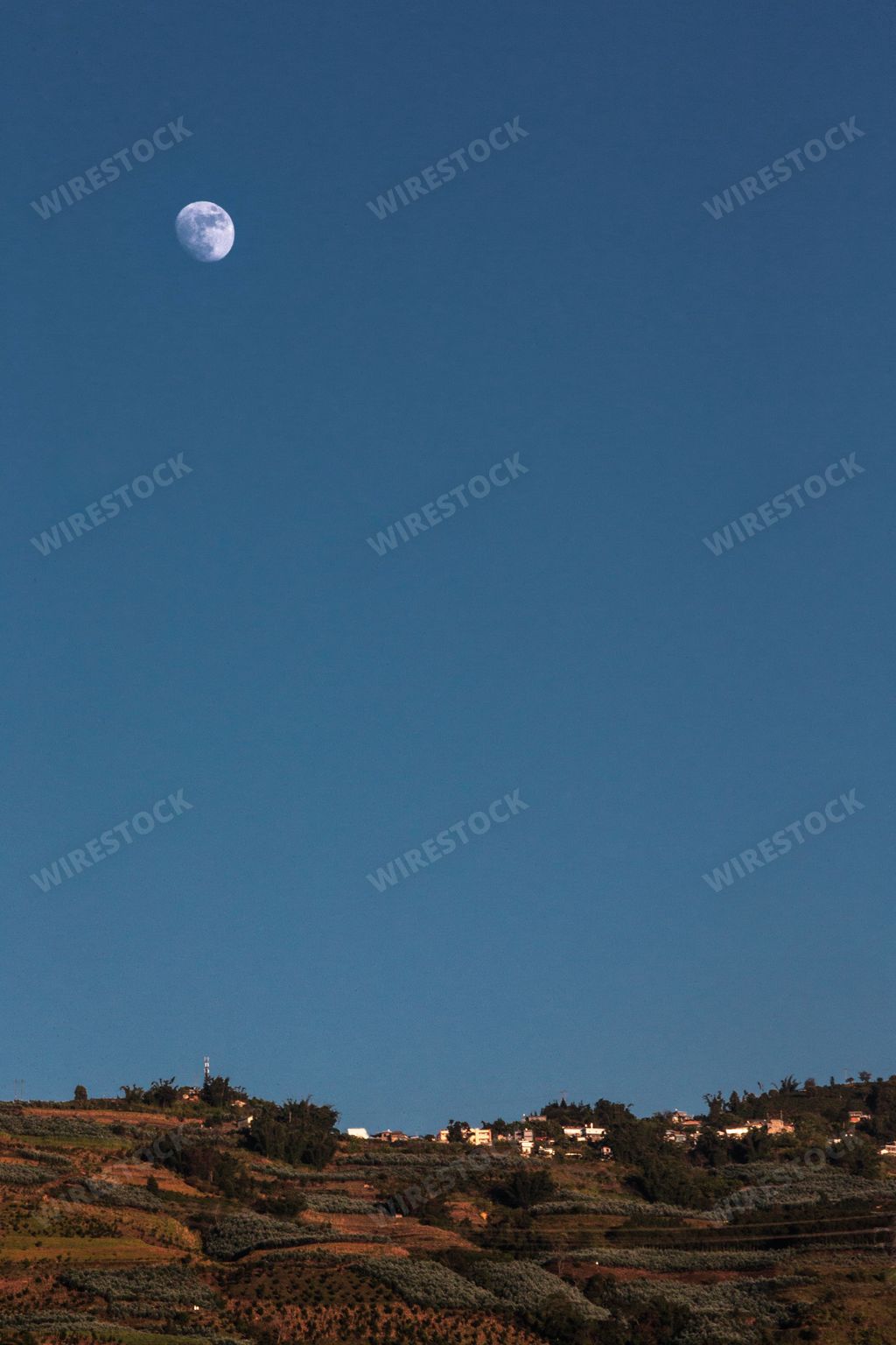 A beautiful landscape of the moon over a village
