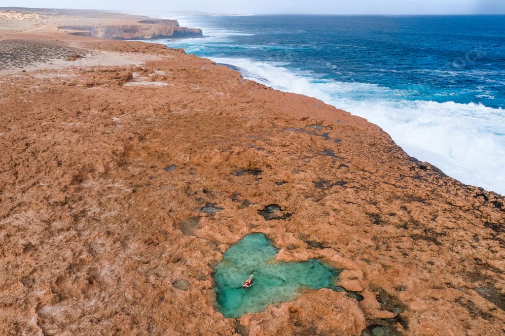 A young woman enjoying her vacation on the cliff by the sea