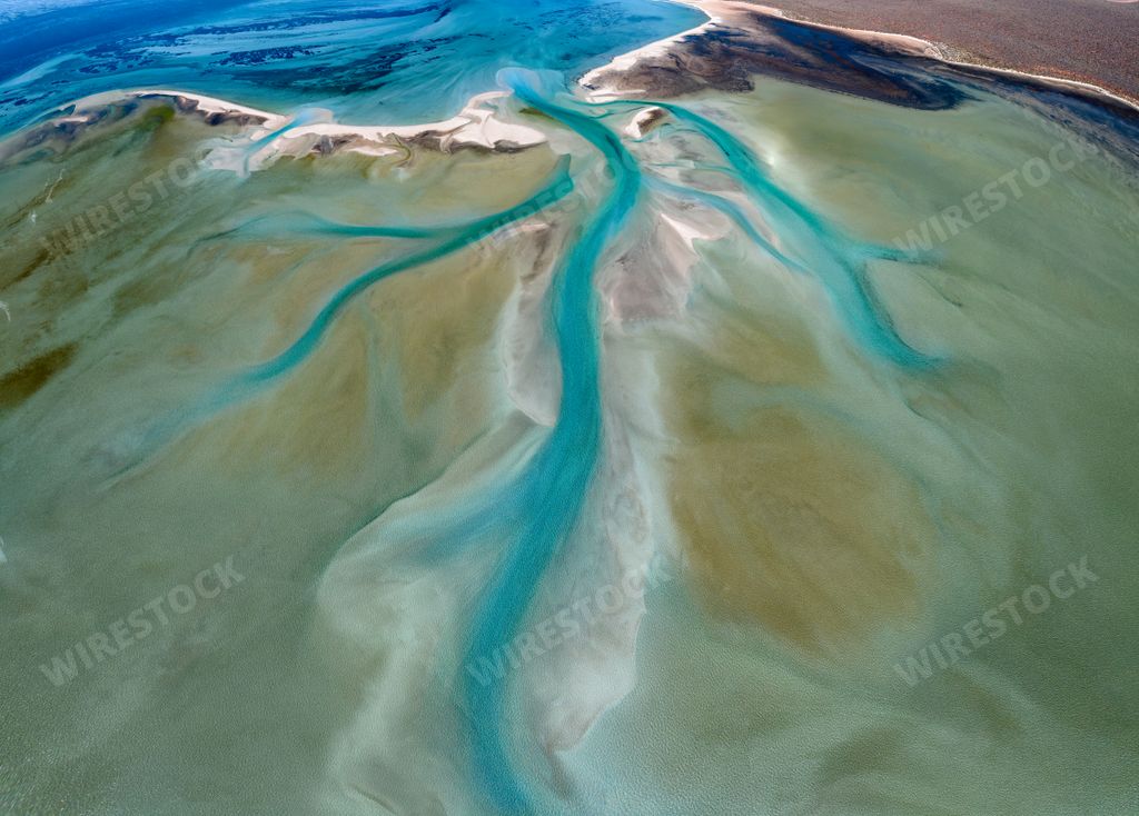 An aerial view of tidal wetlands with tranquil turquoise waters and golden sand at shark bay in western Australia