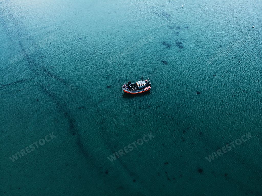An aerial shot of a fishi boat at sea