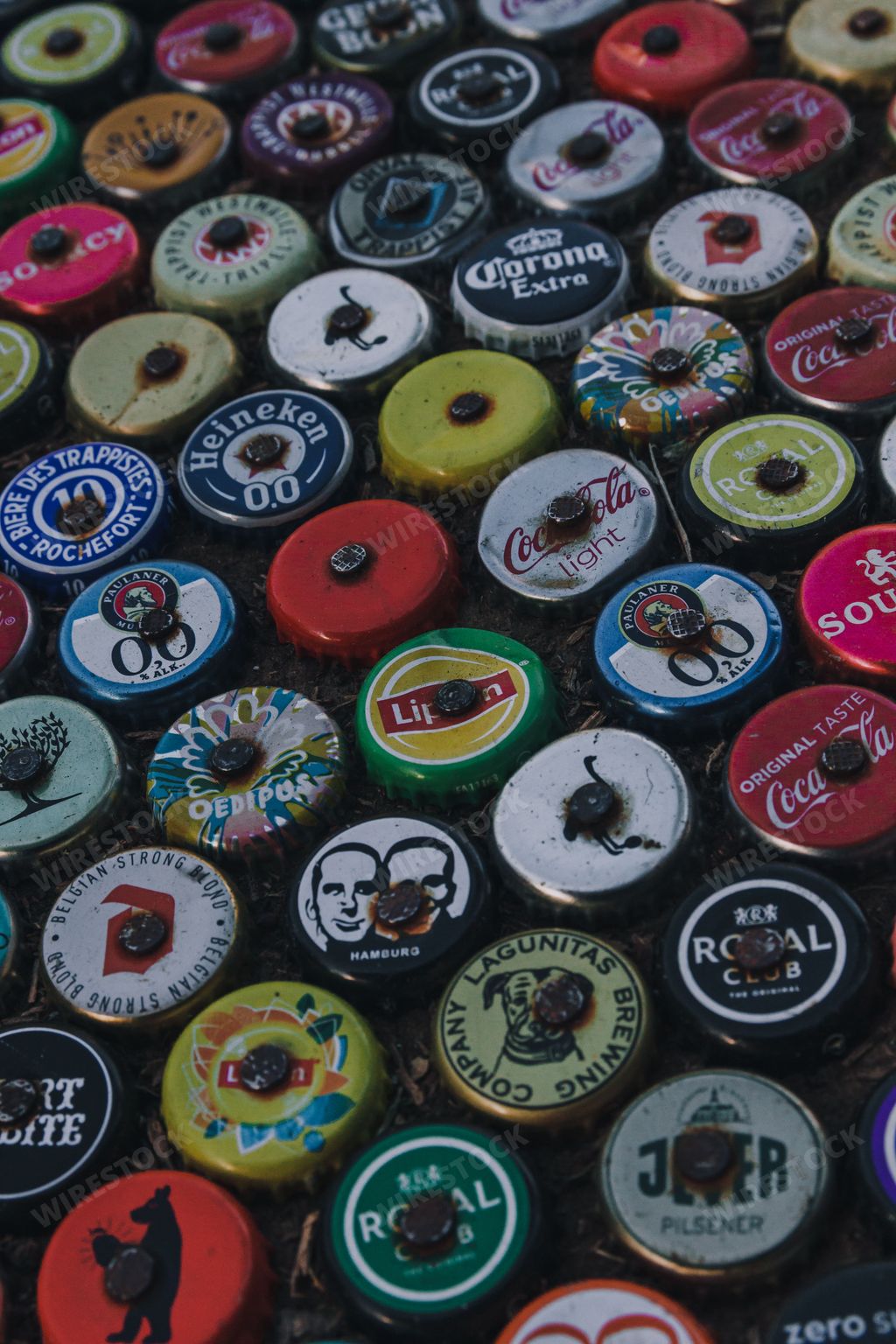 A vertical shot of different beverage company bottle caps collection in Netherlands, Amsterdam