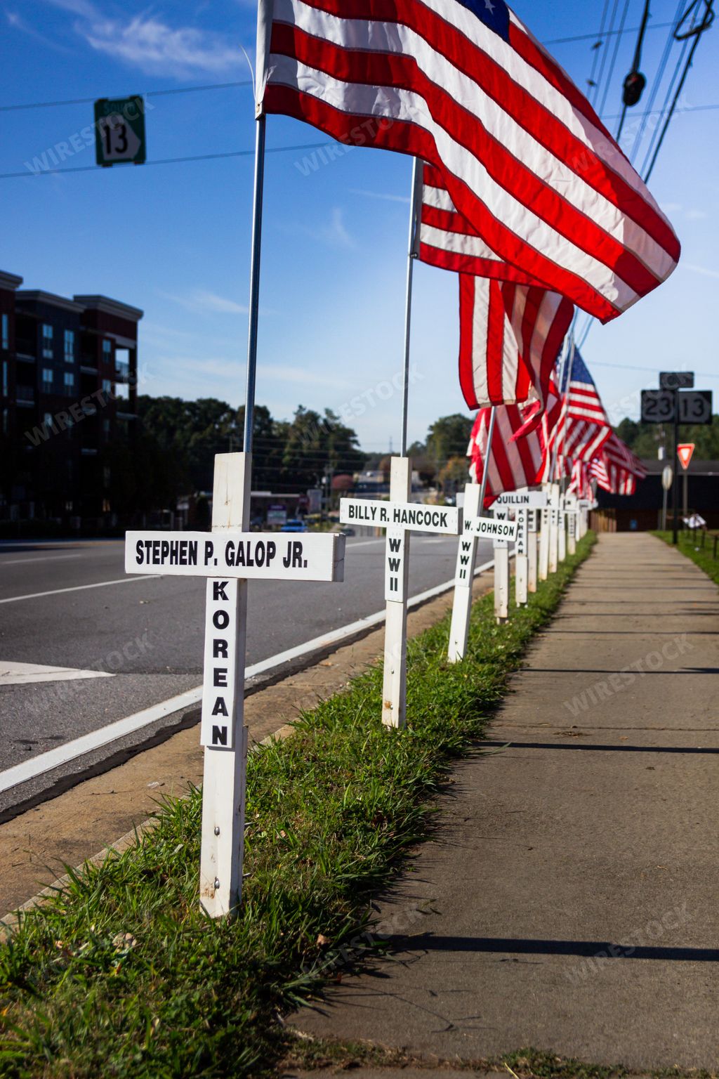 Duluth, Georgia / United States - November 6, 2020: White crosses and American flags line a city street in memory of past resident fallen soldiers