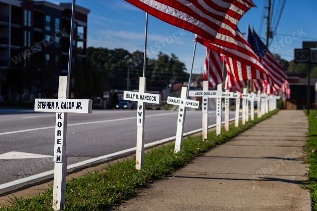 Duluth, Georgia / United States - November 6, 2020: White crosses and American flags line a city street in memory of past resident fallen soldiers