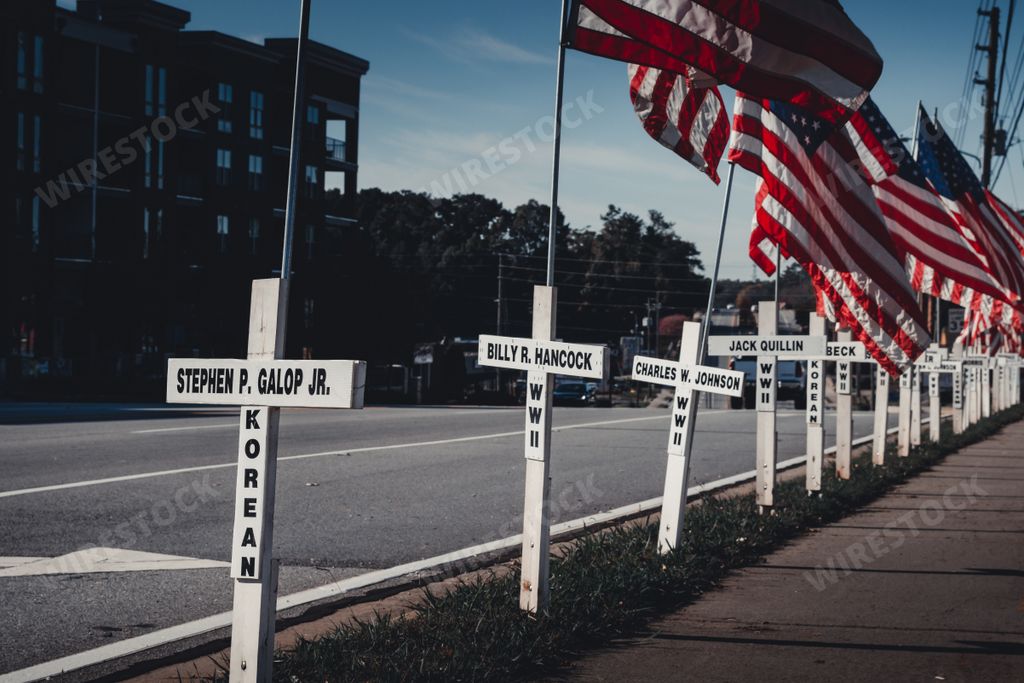 Duluth, Georgia / United States - November 6, 2020: White crosses and American flags line a city street in memory of past resident fallen soldiers