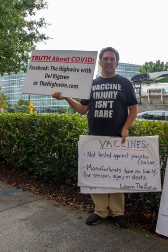 An anti-vaccine protester stands outside of the CDC headquarters in ...